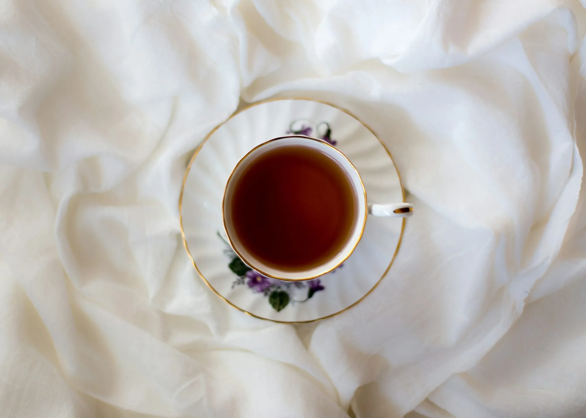 Tasse Tee auf hellem Leinen, von oben